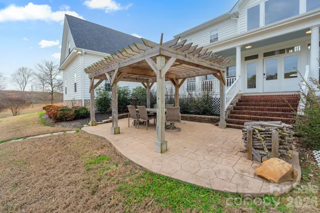 a patio with a table and chairs and potted plants