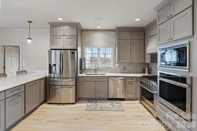 a kitchen with white cabinets and stainless steel appliances