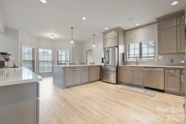 a large kitchen with stainless steel appliances kitchen island a large counter top and a sink