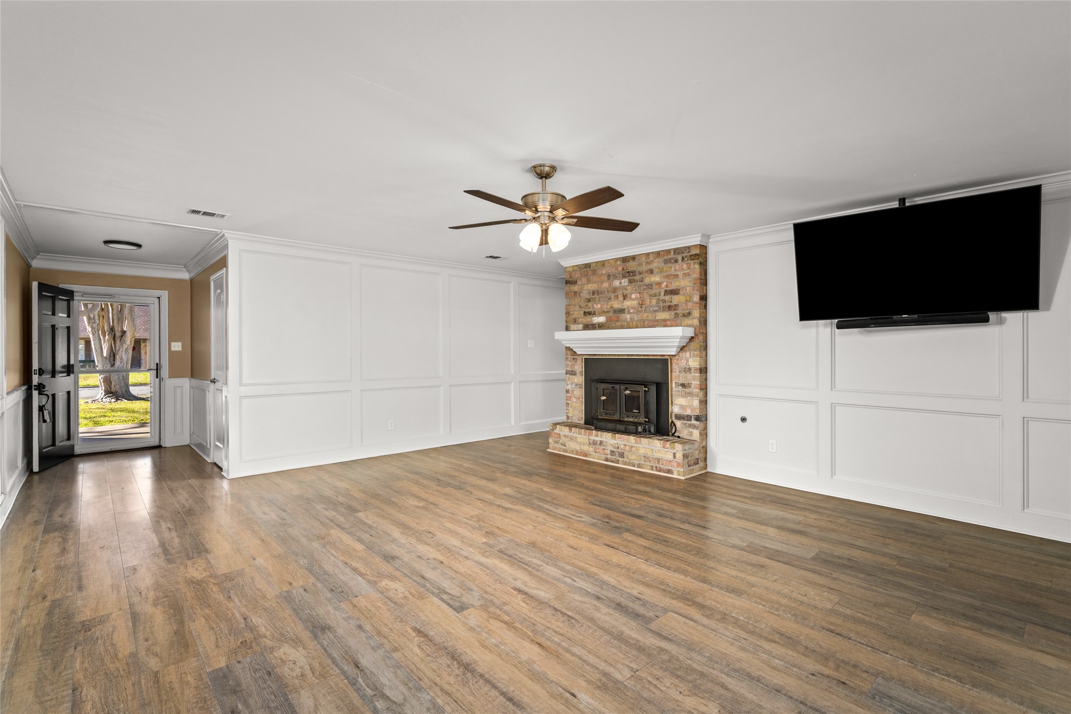 3603 Glenmeadow Drive Rosenberg, TX 77471 - Photo 14 of 27 a view of a livingroom with a flat screen tv a ceiling fan and wooden floor