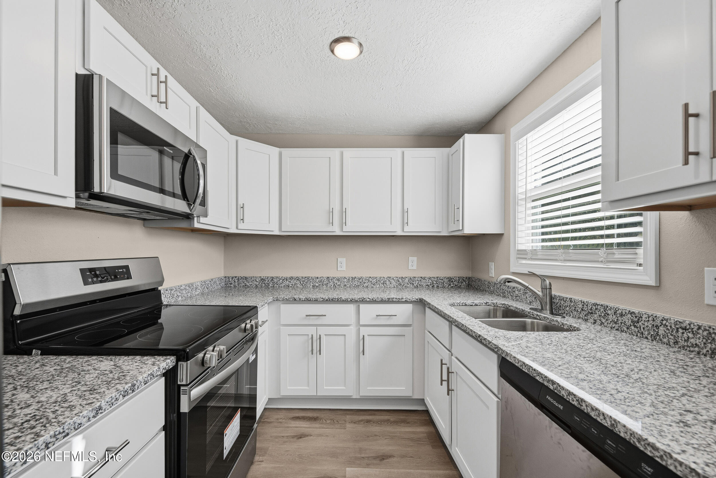 1643 Spruce Street Green Cove Springs, FL 32043 - Photo 12 of 31 a kitchen with granite countertop a sink a stove and microwave