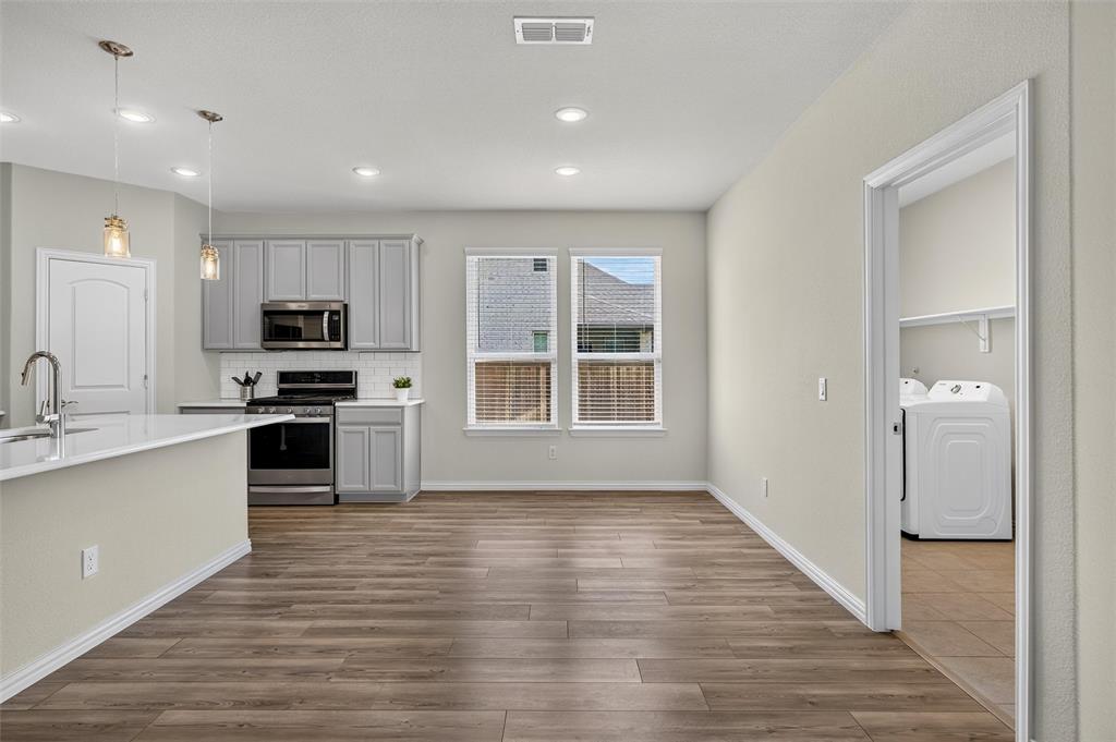 8715 Royal Star Road Rowlett, TX 75089 - Photo 14 of 39 Open-concept kitchen and dining area featuring wood-finish flooring, recessed lighting, and a kitchen island with pendant lighting
