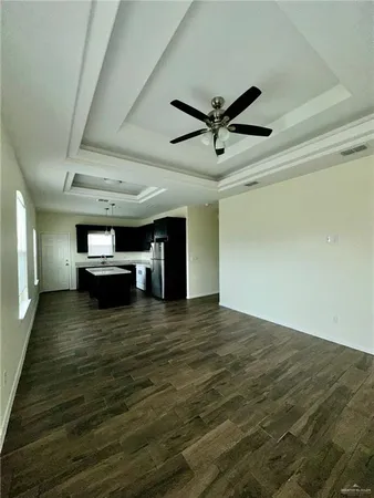 an empty room with wooden floor closet and windows
