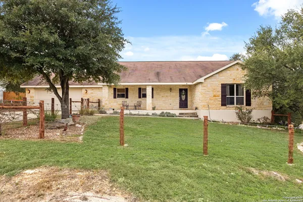 a view of a house with a backyard and a tree