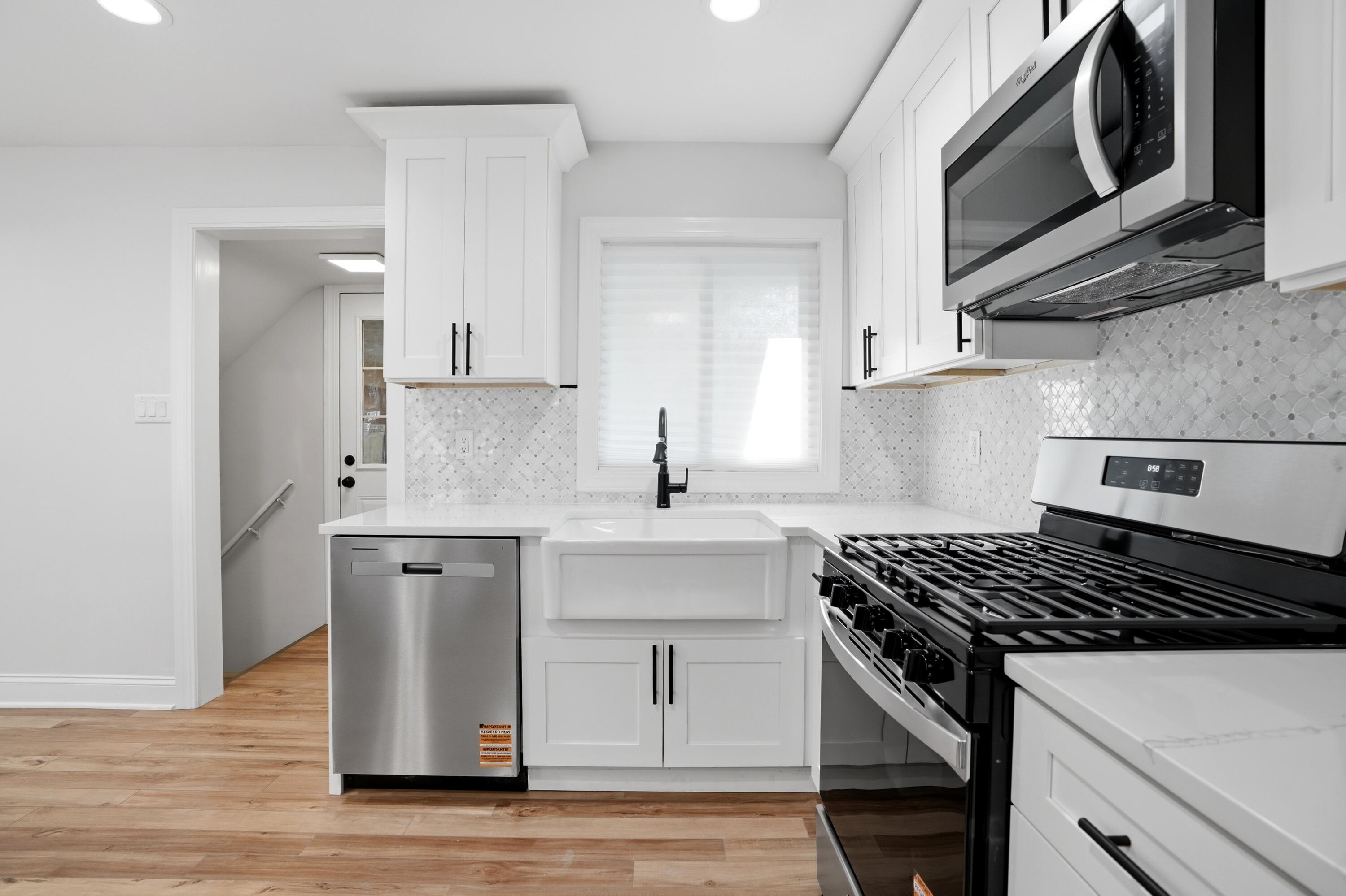 1960 Chase Street Gary, IN 46404 - Photo 28 of 45 a kitchen with cabinets stainless steel appliances and wooden floor
