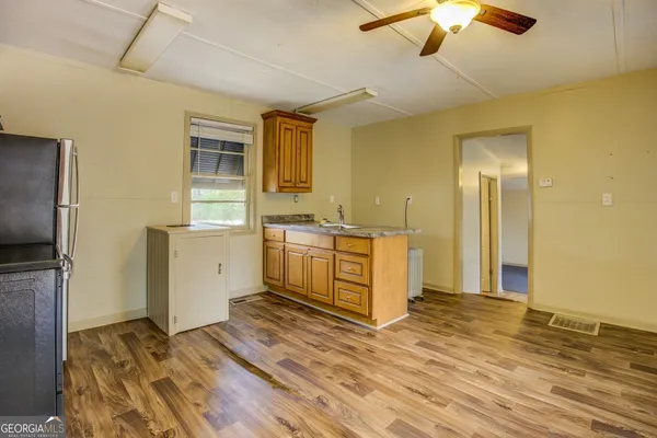 a room with a bed and a view of kitchen