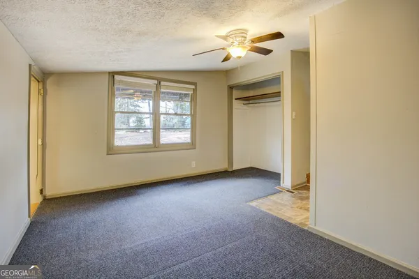 an empty room with windows and closet
