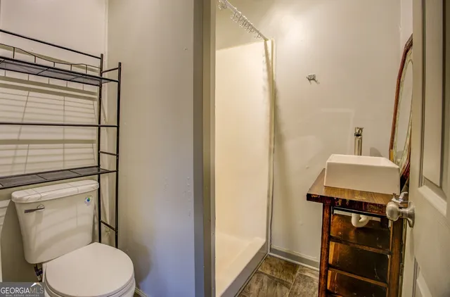 a bathroom with a toilet a sink and shower