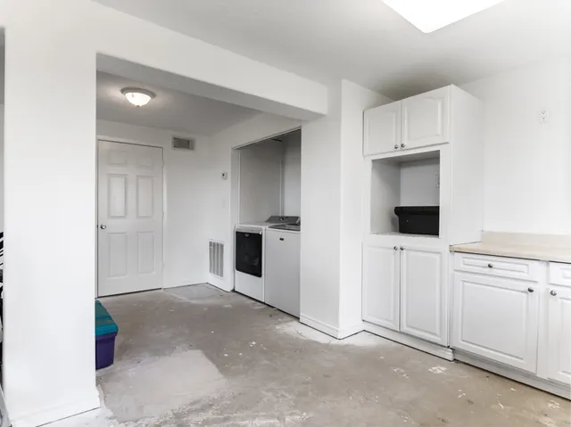 a view of a kitchen with white cabinets