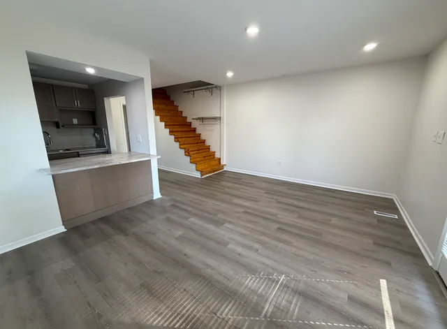 wooden floor in an empty room with a kitchen