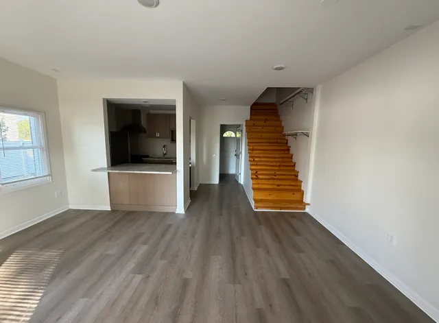 a view of a livingroom with wooden floor and white walls