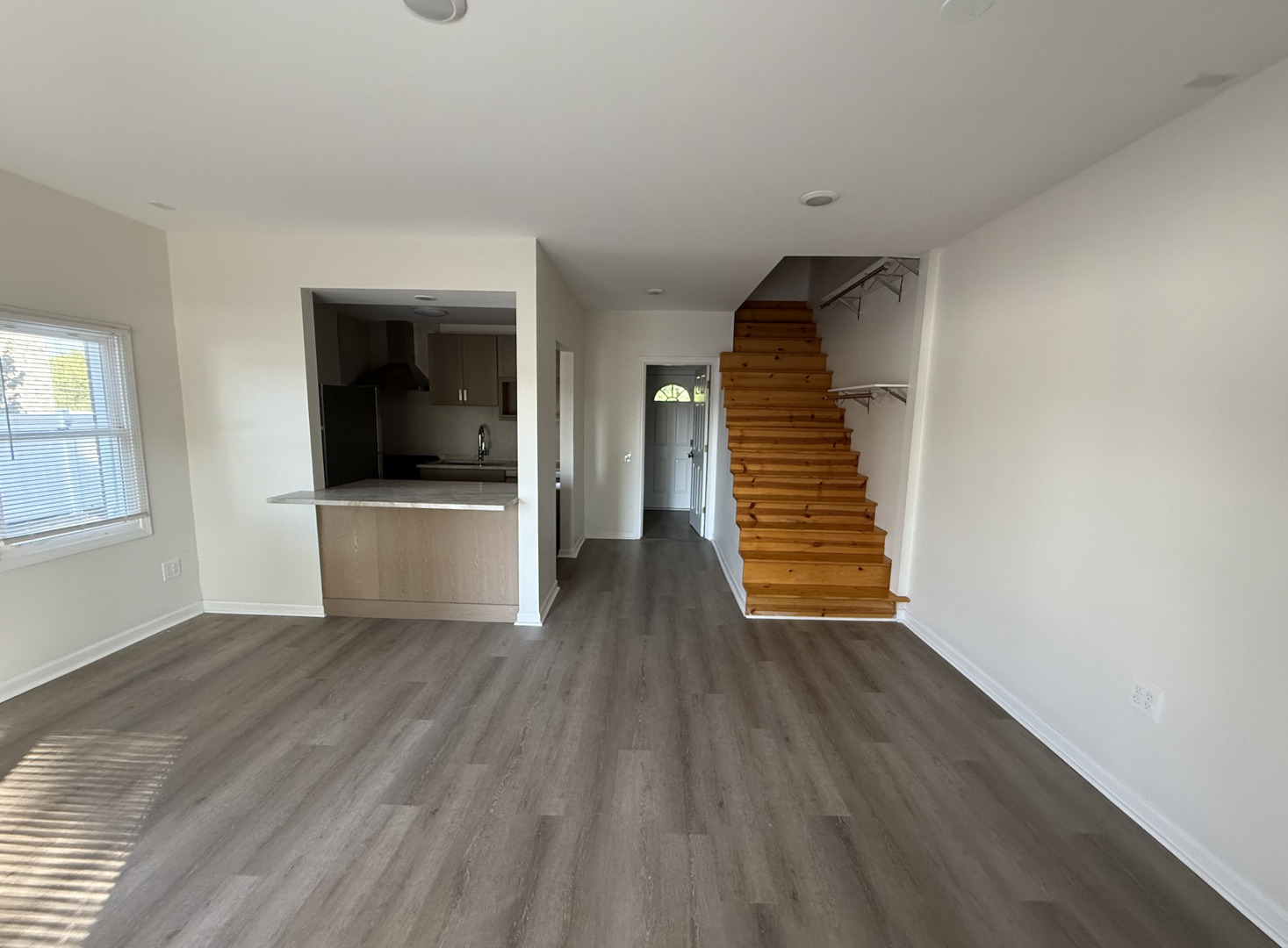 59 9s115 Route, Unit 1 Naperville, IL 60564 - Photo 3 of 12 a view of a livingroom with wooden floor and white walls