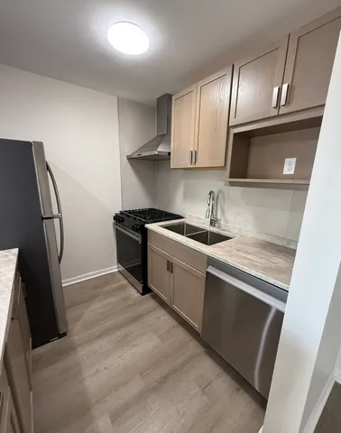 a kitchen that has a sink a refrigerator and cabinets