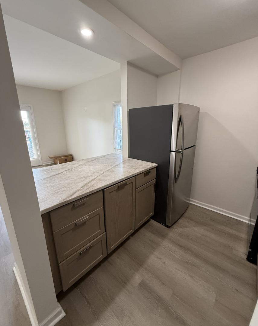 59 9s115 Route, Unit 1 Naperville, IL 60564 - Photo 6 of 12 a room with a wooden floor and cabinets