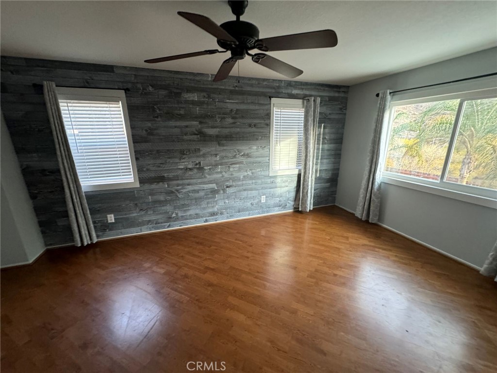 31781 Canyon Estates Drive Lake Elsinore, CA 92532 - Photo 12 of 25 an empty room with wooden floor and windows