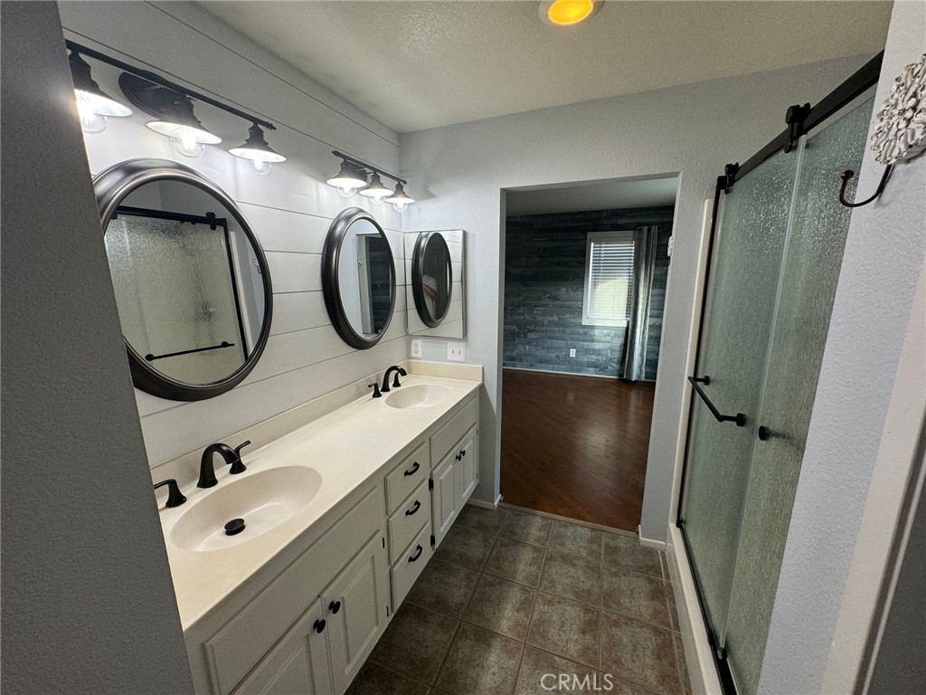 31781 Canyon Estates Drive Lake Elsinore, CA 92532 - Photo 14 of 25 a bathroom with a double vanity sink and mirror with bathtub