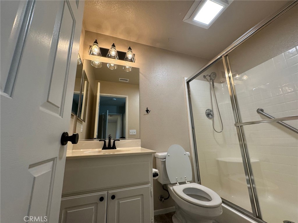 31781 Canyon Estates Drive Lake Elsinore, CA 92532 - Photo 9 of 25 a bathroom with a sink a toilet a mirror and shower