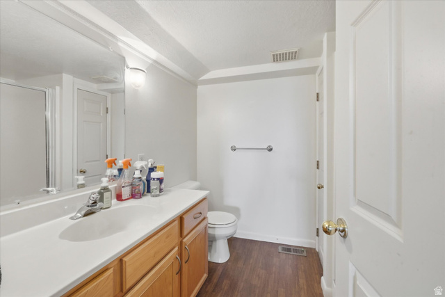 2887 View Crest Circle North Logan, UT 84341 - Photo 33 of 37 Bathroom featuring vanity, dark wood finished floors, a shower stall, and a textured ceiling