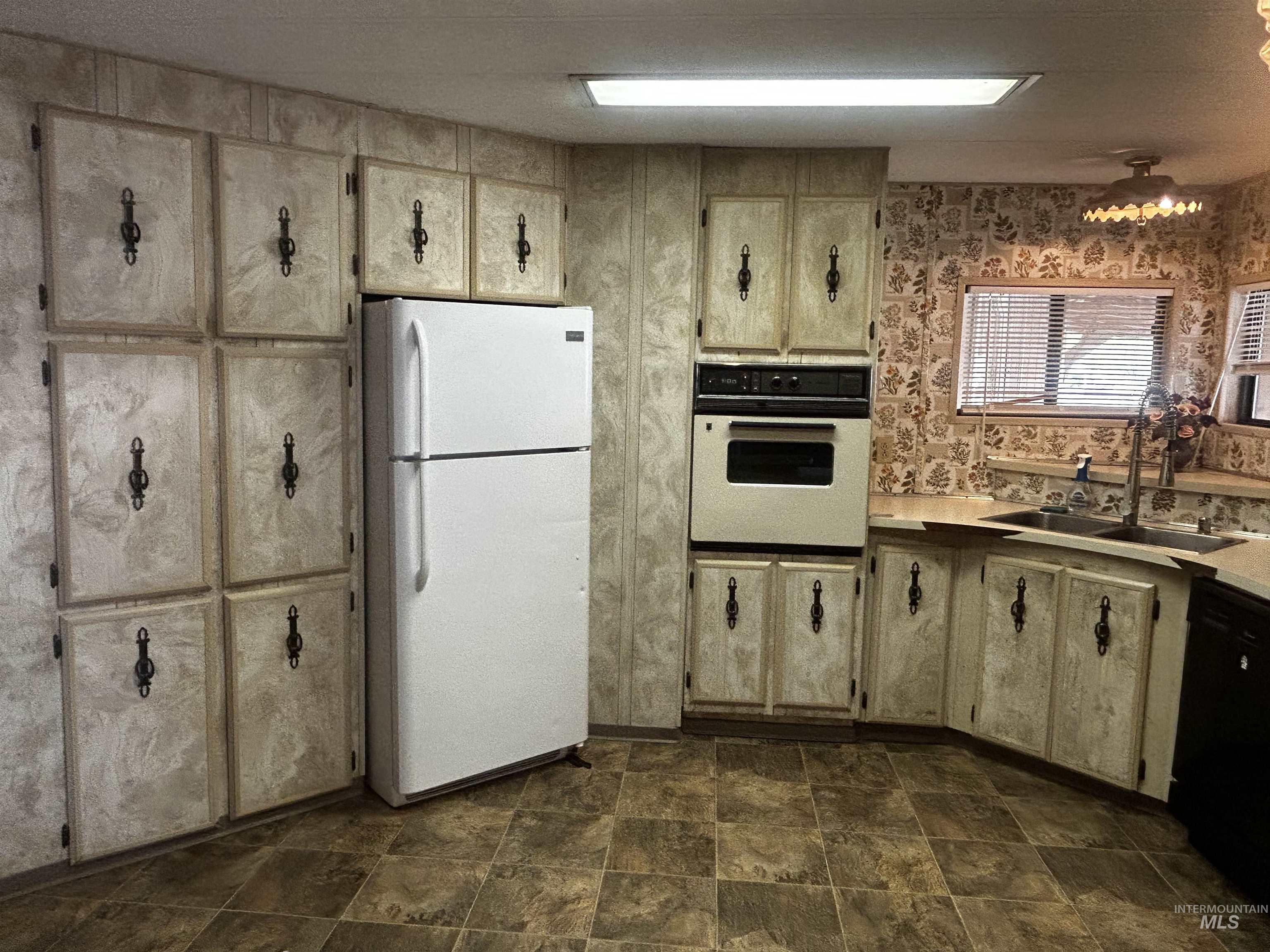 10165 West Claudia Road Boise, ID 83714 - Photo 18 of 30 Kitchen featuring extensive cabinetry, built-in wall oven, double basin sink, and tiled flooring