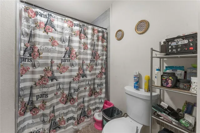 a bathroom with a toilet and a shower curtain