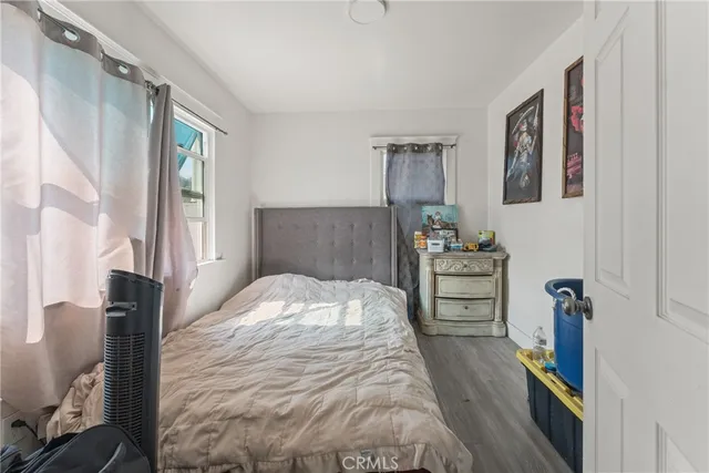 a bedroom with a bed and a flat tv screen on the dresser