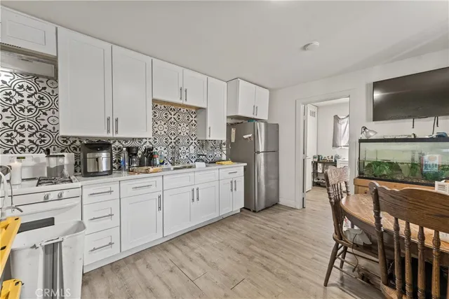 a kitchen with stainless steel appliances white cabinets and wooden floors