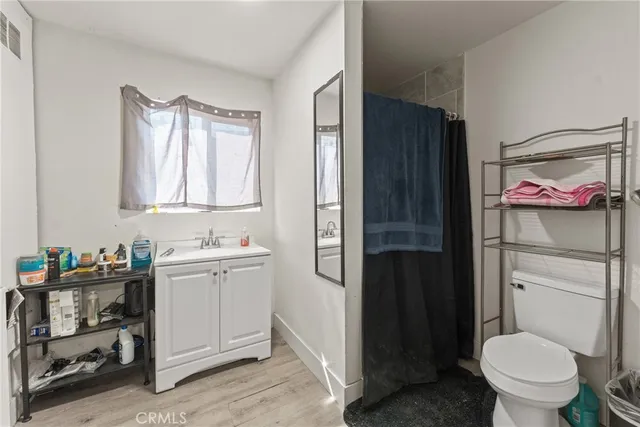 a bathroom with a toilet sink vanity tub and window