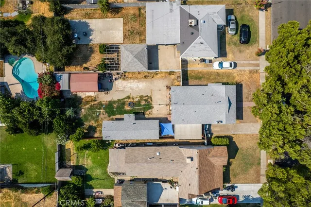 an aerial view of residential houses with outdoor space and parking