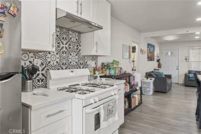 a kitchen with stainless steel appliances a stove a sink and a refrigerator