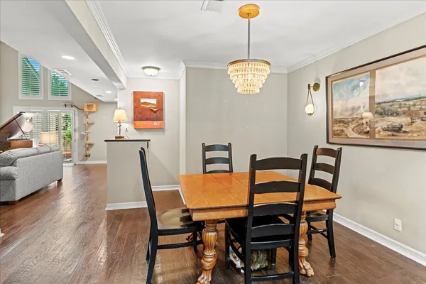 a view of a dining room with furniture wooden floor and a chandelier