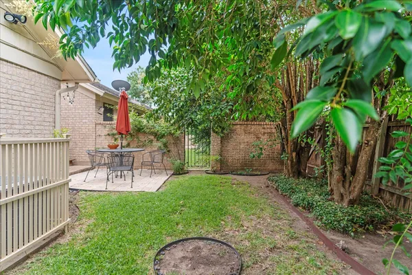 a view of a backyard with table and chairs and potted plants