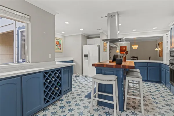 a kitchen with stainless steel appliances kitchen island granite countertop a sink and a refrigerator