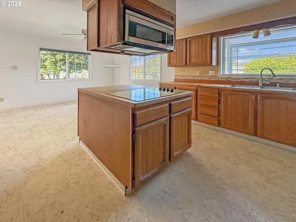 a kitchen with stainless steel appliances granite countertop a sink stove and microwave