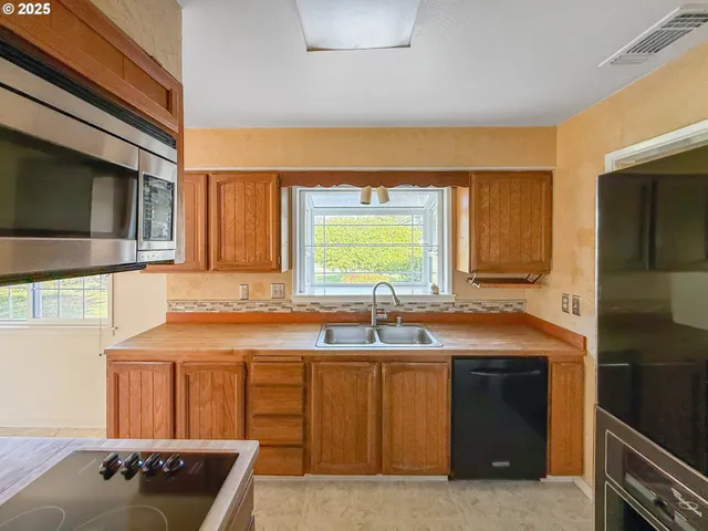 a kitchen with a sink and a stove top oven