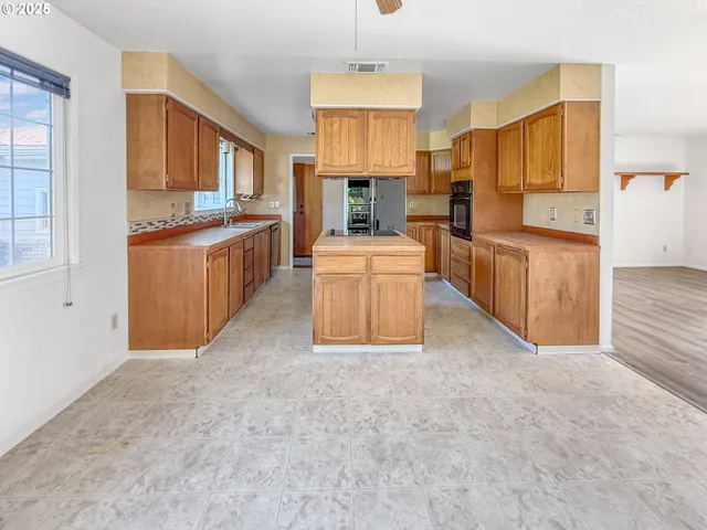a large kitchen with cabinets and stainless steel appliances