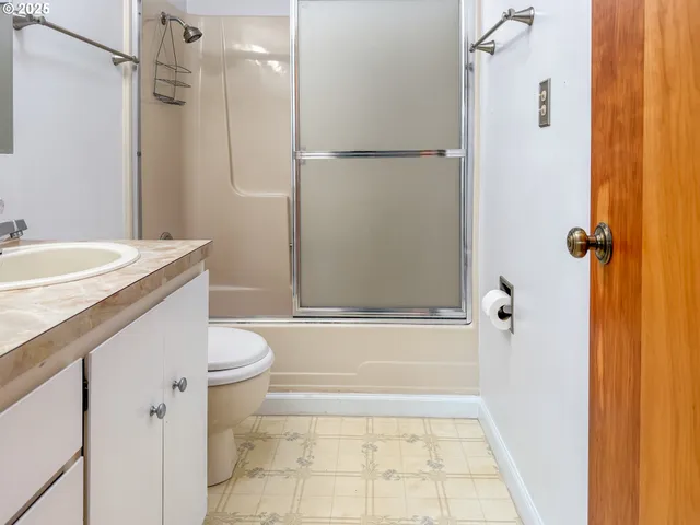 a bathroom with a granite countertop sink toilet and shower