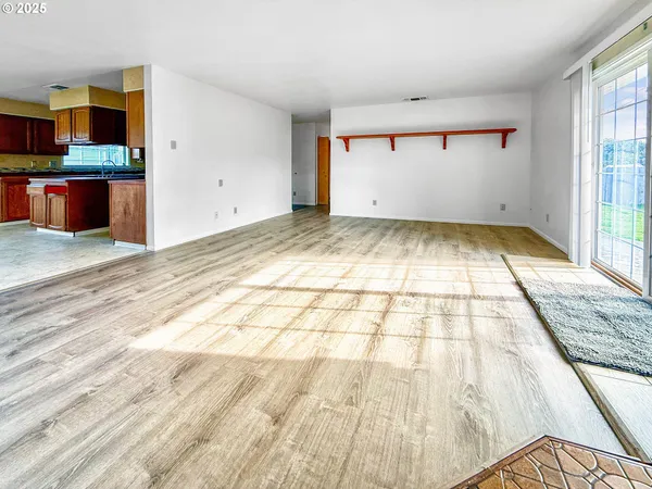 a view of empty room with wooden floor and windows