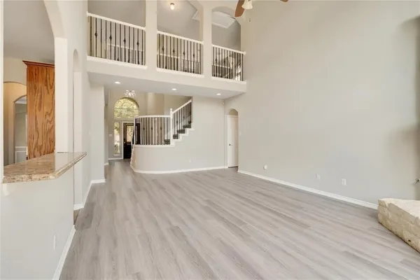 an empty room with wooden floor fireplace and windows