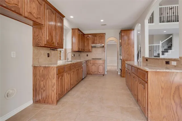 a view of a kitchen with stainless steel appliances wooden floor and a window