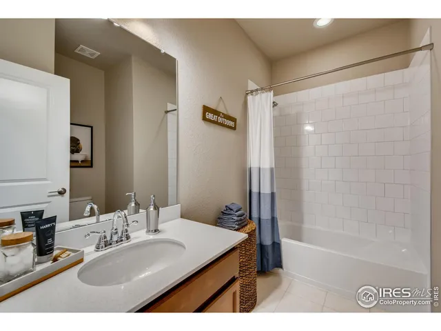 a bathroom with a granite countertop sink mirror bathtub and shower