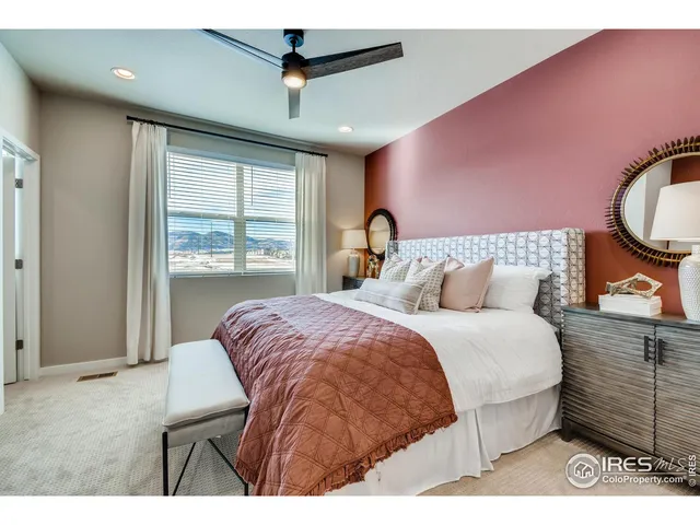 a bedroom with a bed a chandelier and a window