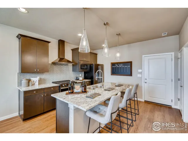 a kitchen with stainless steel appliances kitchen island granite countertop a sink refrigerator and cabinets