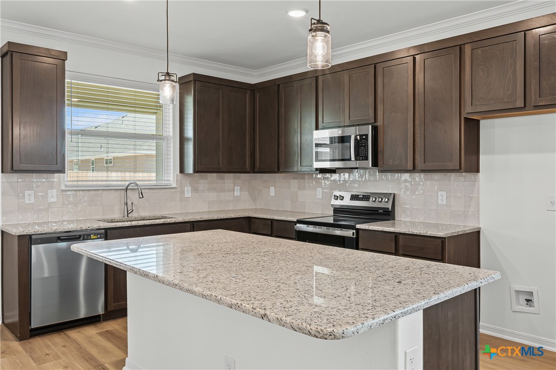 7810 Timber Holw Lane Temple, TX 76502 - Photo 14 of 32 a kitchen with granite countertop a sink a counter top space cabinets and stainless steel appliances