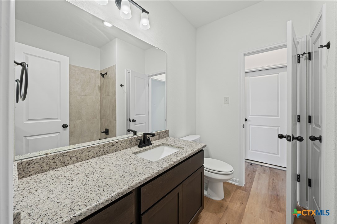 7810 Timber Holw Lane Temple, TX 76502 - Photo 20 of 32 a bathroom with a granite countertop sink a toilet and shower