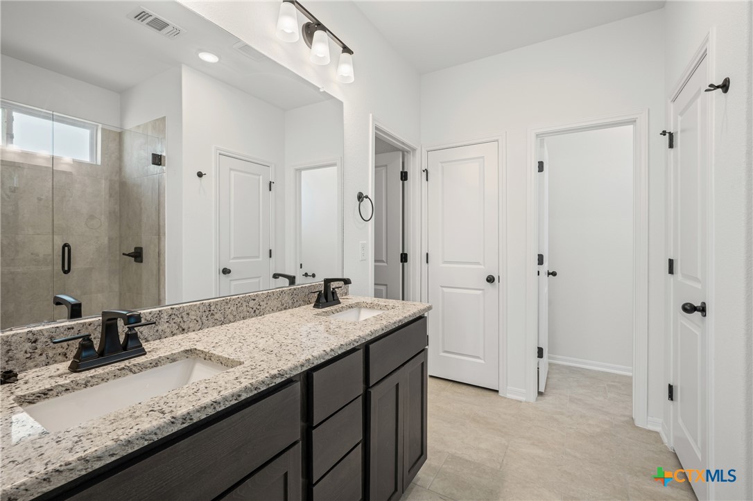 7810 Timber Holw Lane Temple, TX 76502 - Photo 26 of 32 a bathroom with a granite countertop sink and a mirror
