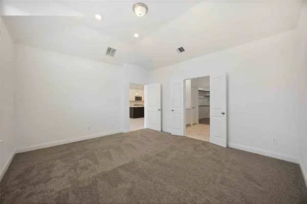 a view of empty room with a kitchen
