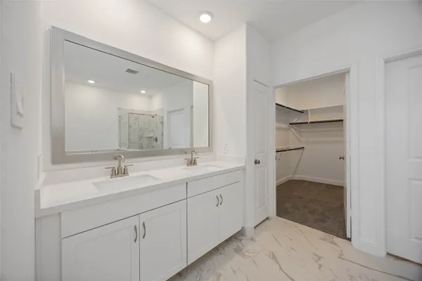 a bathroom with a double vanity sink mirror and shower