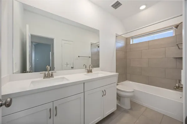 a bathroom with a bathtub shower sink mirror and toilet
