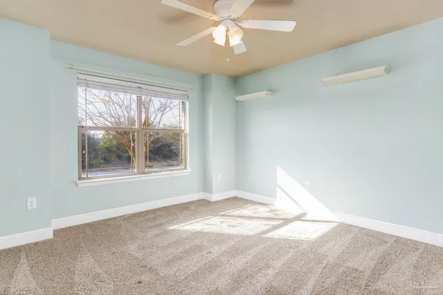 an empty room with fan and entrance