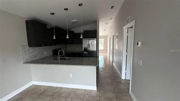 a view of a sink and a refrigerator in a kitchen